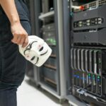 Cybersecurity Checklist! Person holding mask near servers