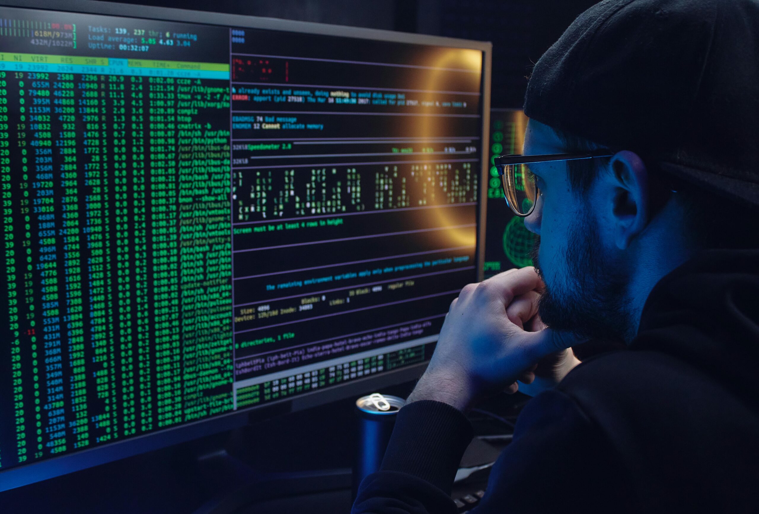 Person in Cybersecurity analyzing data on computer screens.